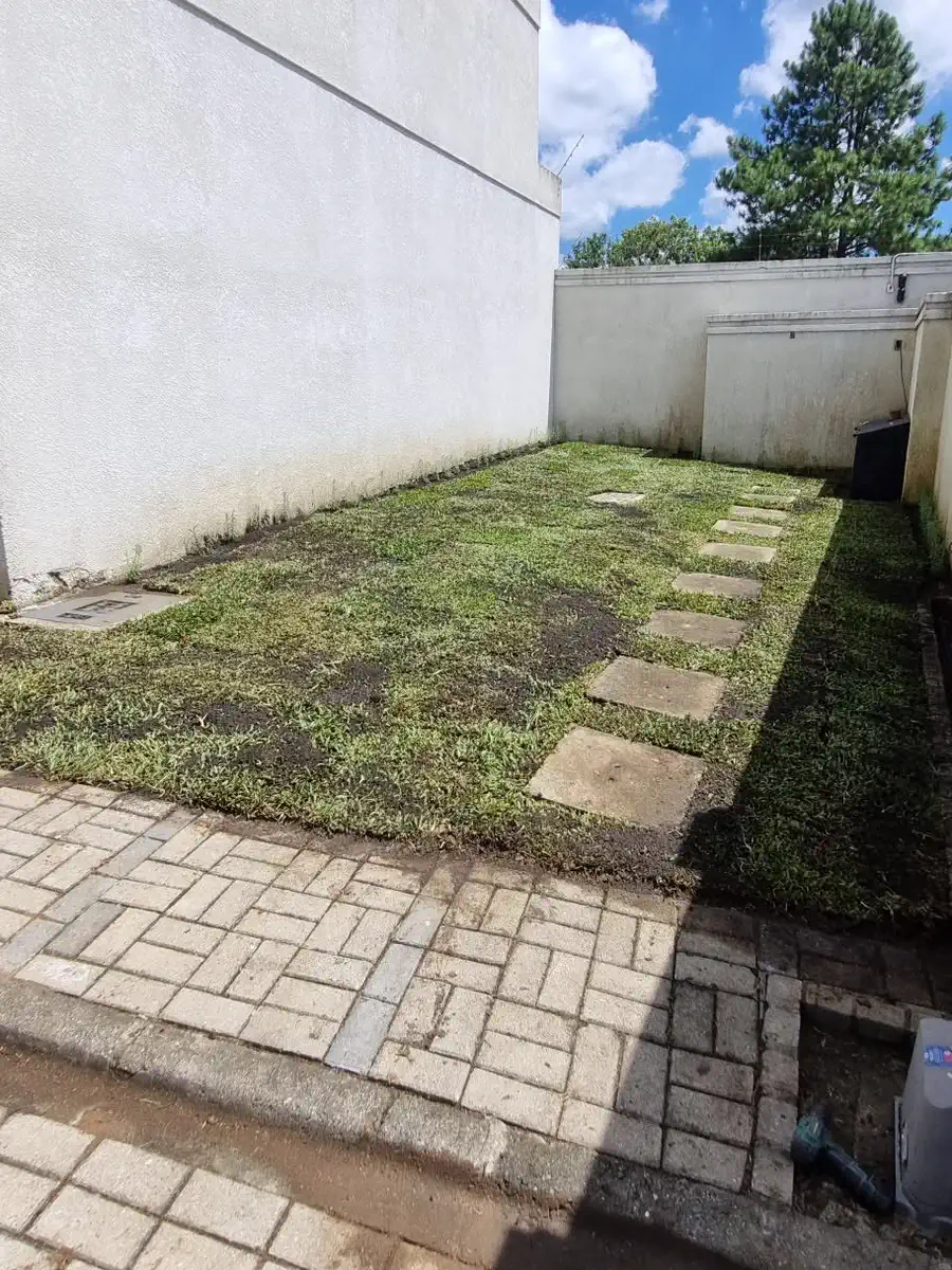 O mesmo quintal depois: gramado novo em placas e área totalmente limpa