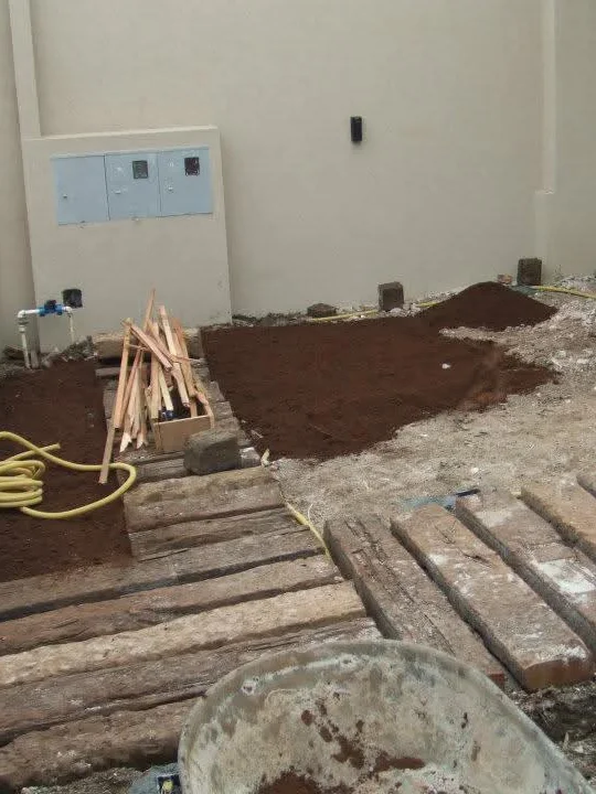 Área residencial antes: terreno com terra batida, entulho e dormentes em instalação