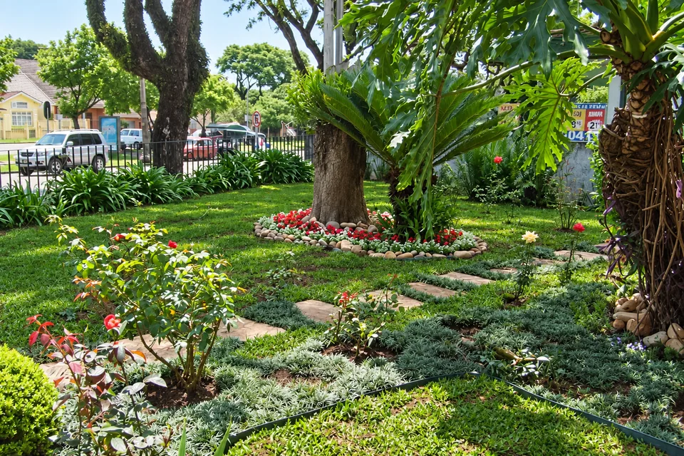 Jardim com canteiros floridos, forração e caminho de pedras